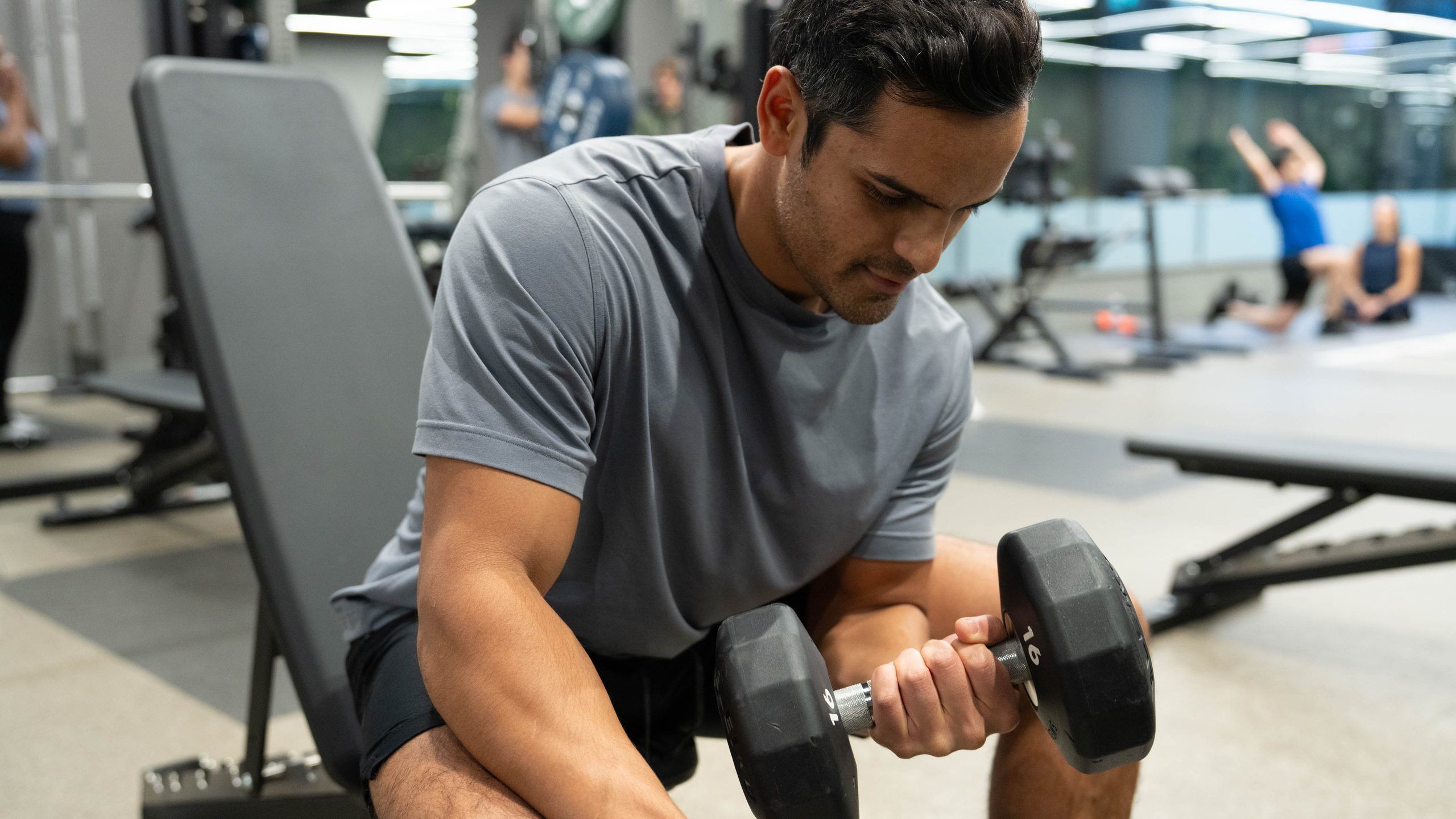 A close view of a man doing a seated dumbbell curl