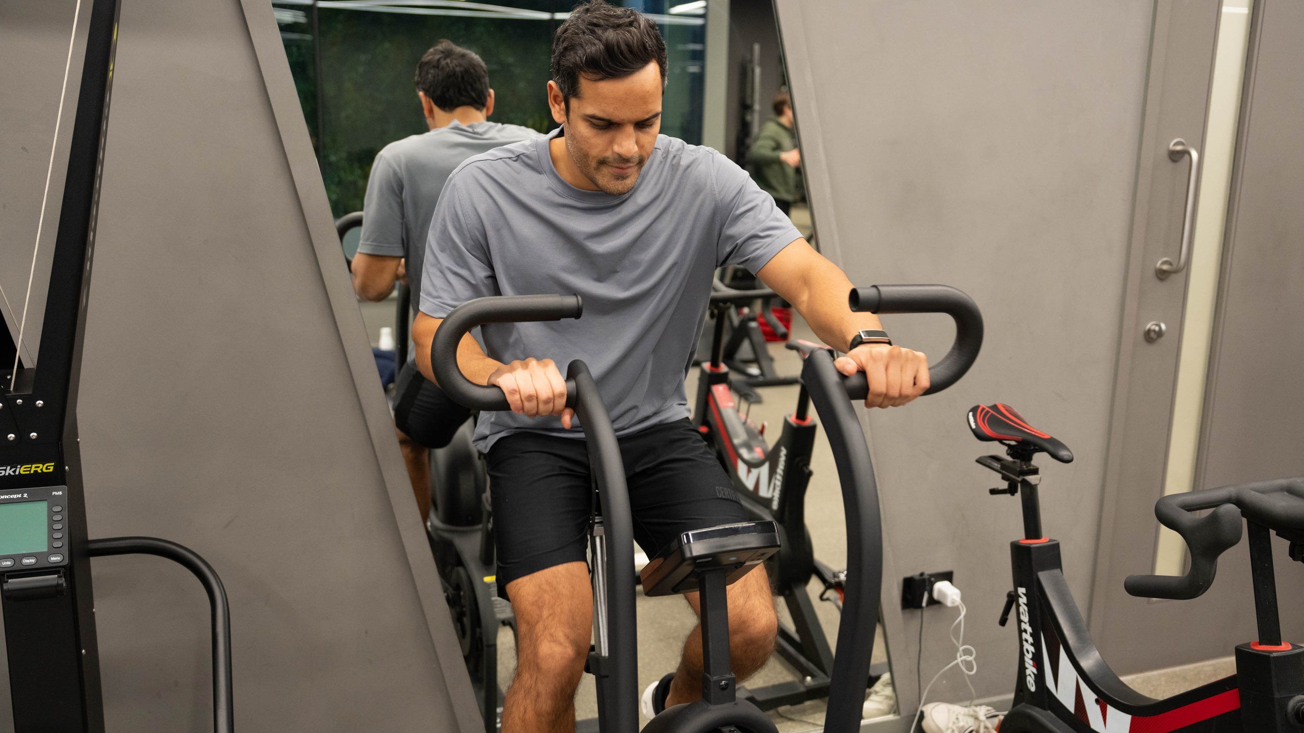 A man riding an air bike on the conditioning floor
