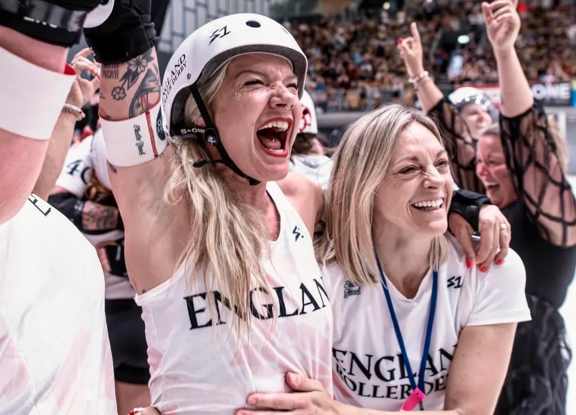 Carly Christensen celebrating with an England skater at the Roller Derby World Cup 2025 in Innsbruck