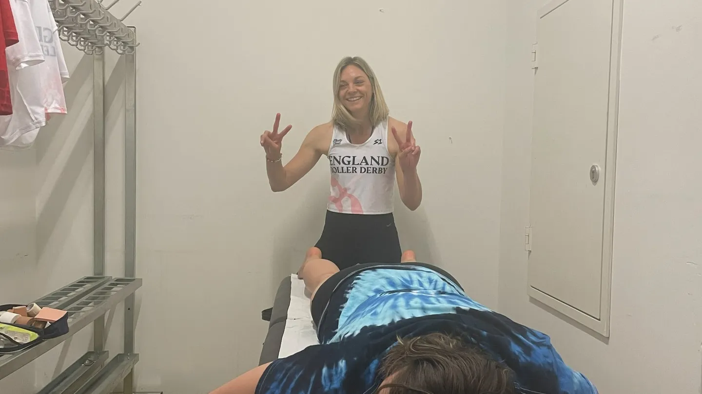 Carly Christensen treating an athlete lying face down on the plinth at the Roller Derby World Cup 2025 in Innsbruck