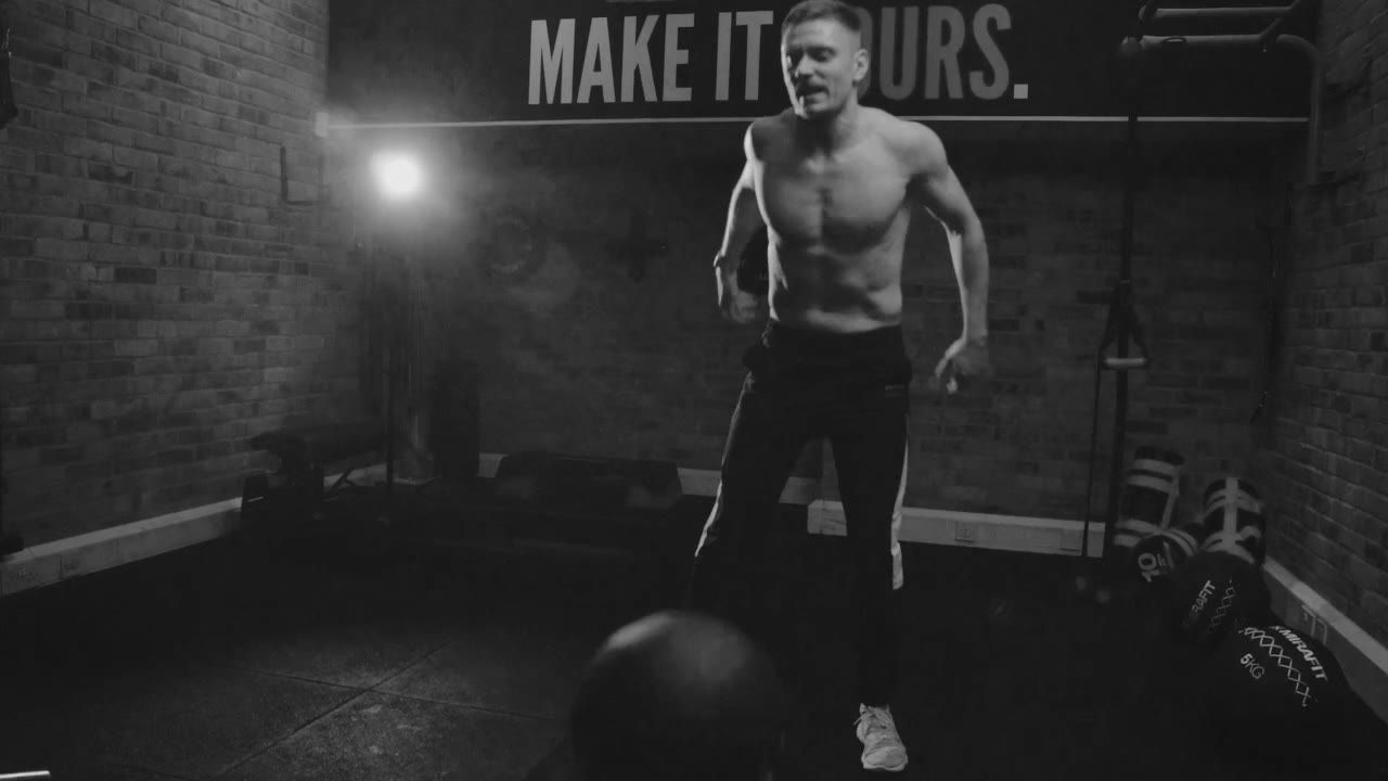 Training at the gym where Colossus PT started, under the "Make it yours" wall lettering, in black and white