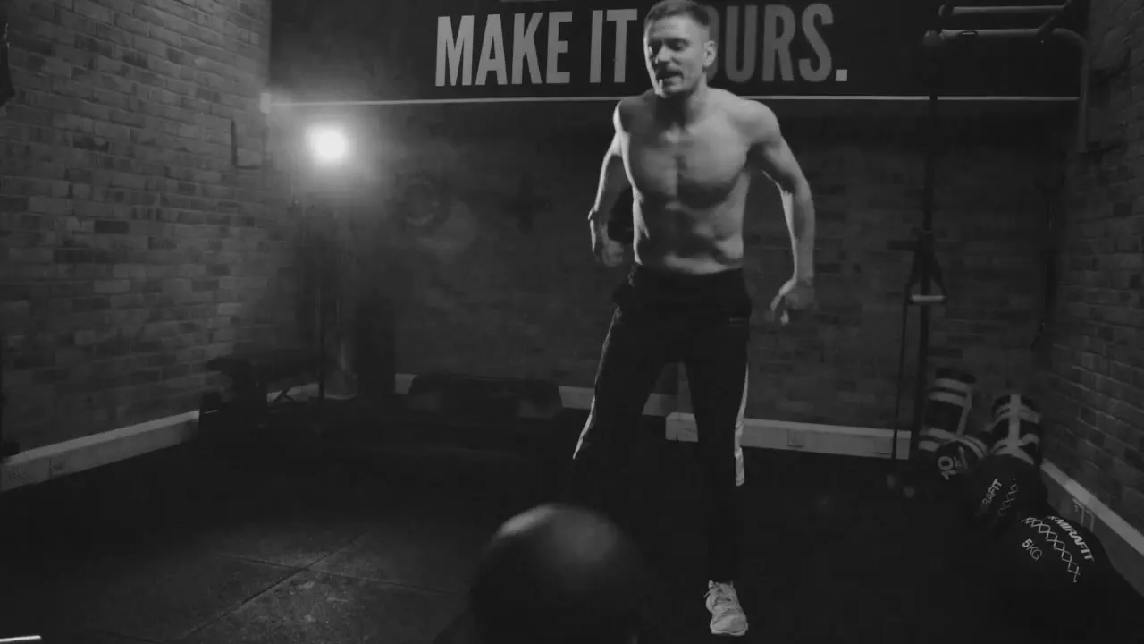 Training at the gym where Colossus PT started, under the "Make it yours" wall lettering, in black and white