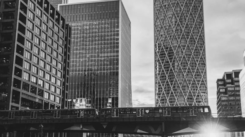 Canary Wharf towers above the DLR viaduct and the dock, in black and white