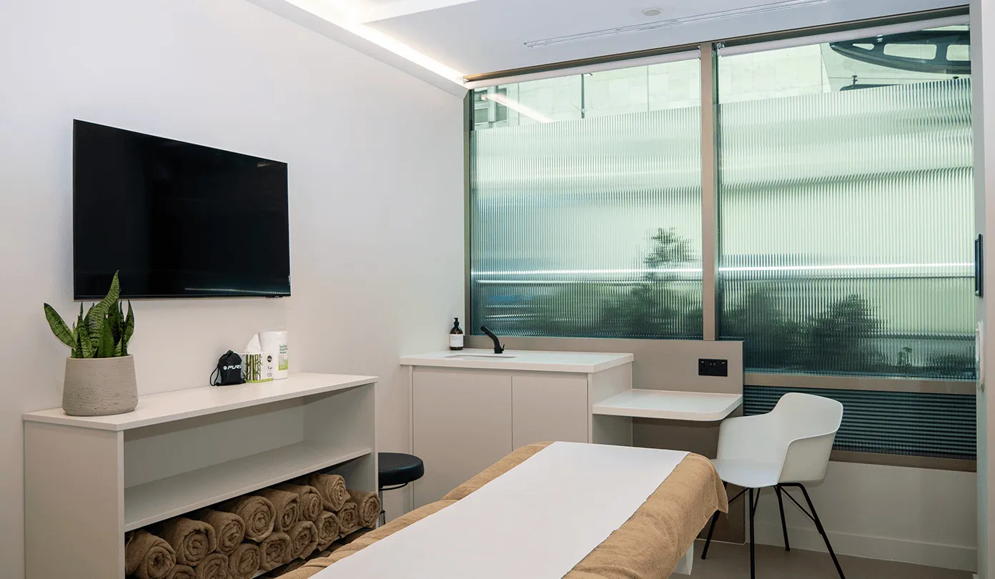 A consulting and treatment room at UNTIL Marylebone, with an examination couch and clinician desk