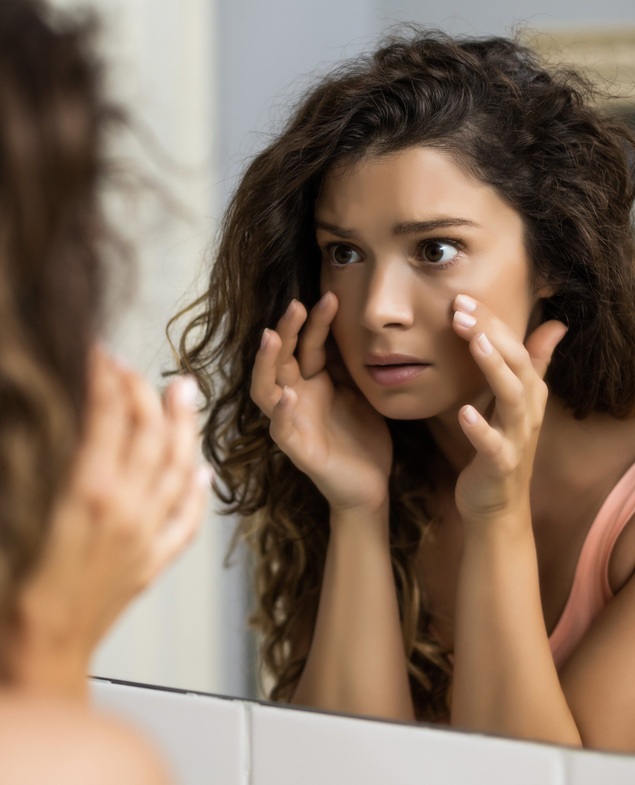 Under-eye area examined in a mirror before tear trough treatment