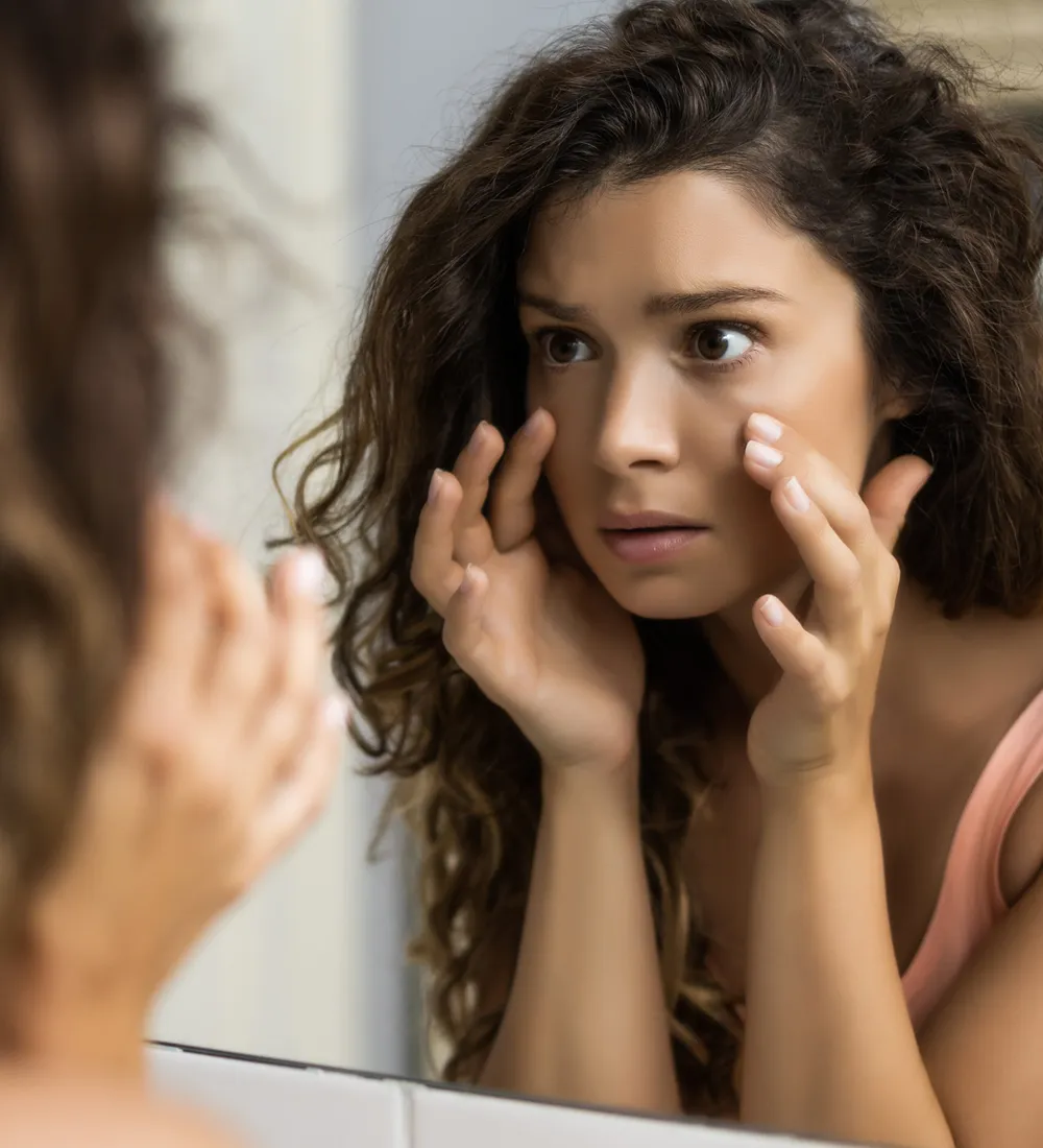 Under-eye area examined in a mirror before tear trough treatment