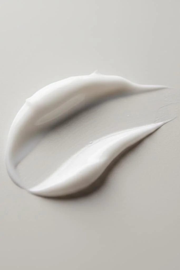 A swatch of skincare cream on a pale surface