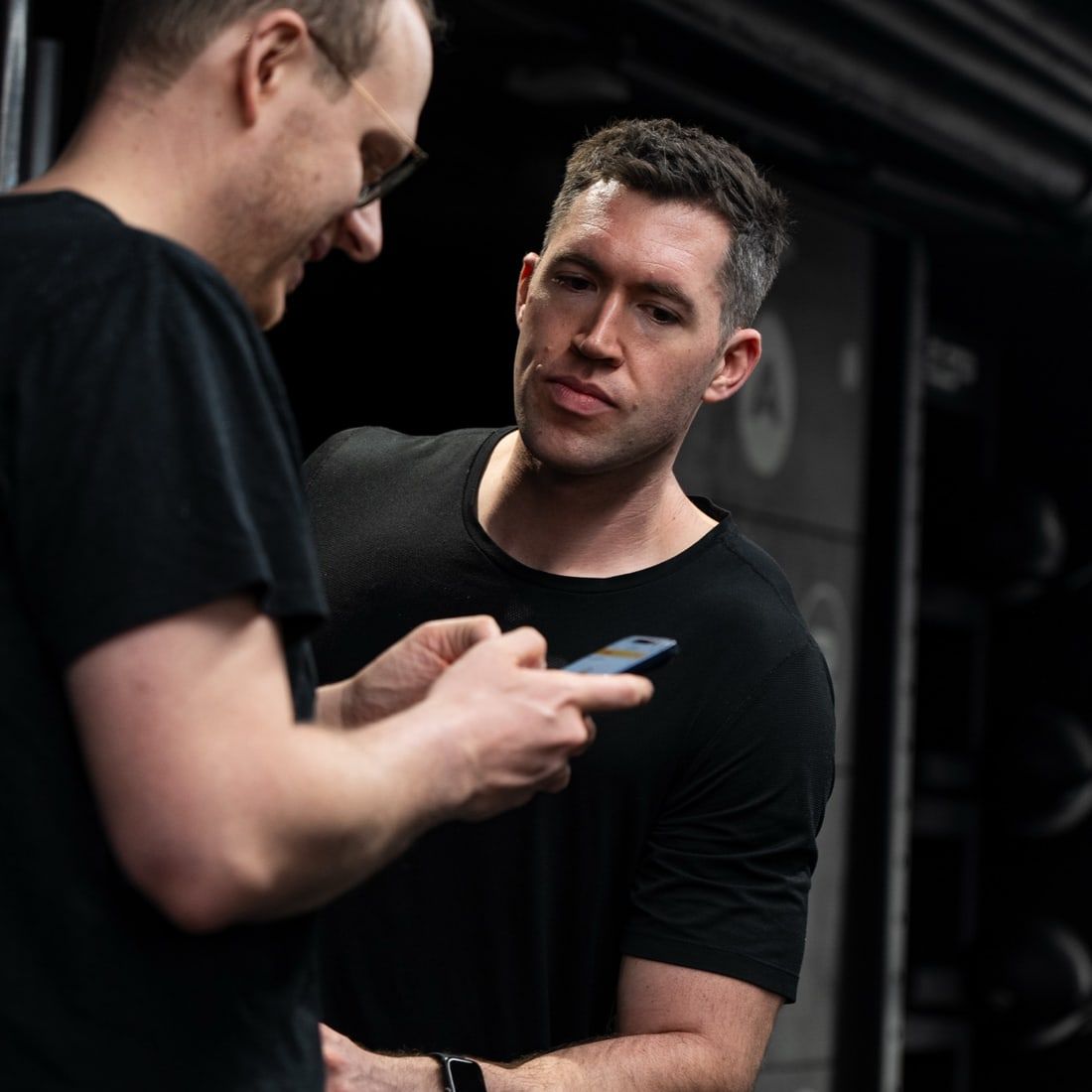 Jasper MacDermot and a client reviewing a training plan on a phone, the check-in his online clients get remotely