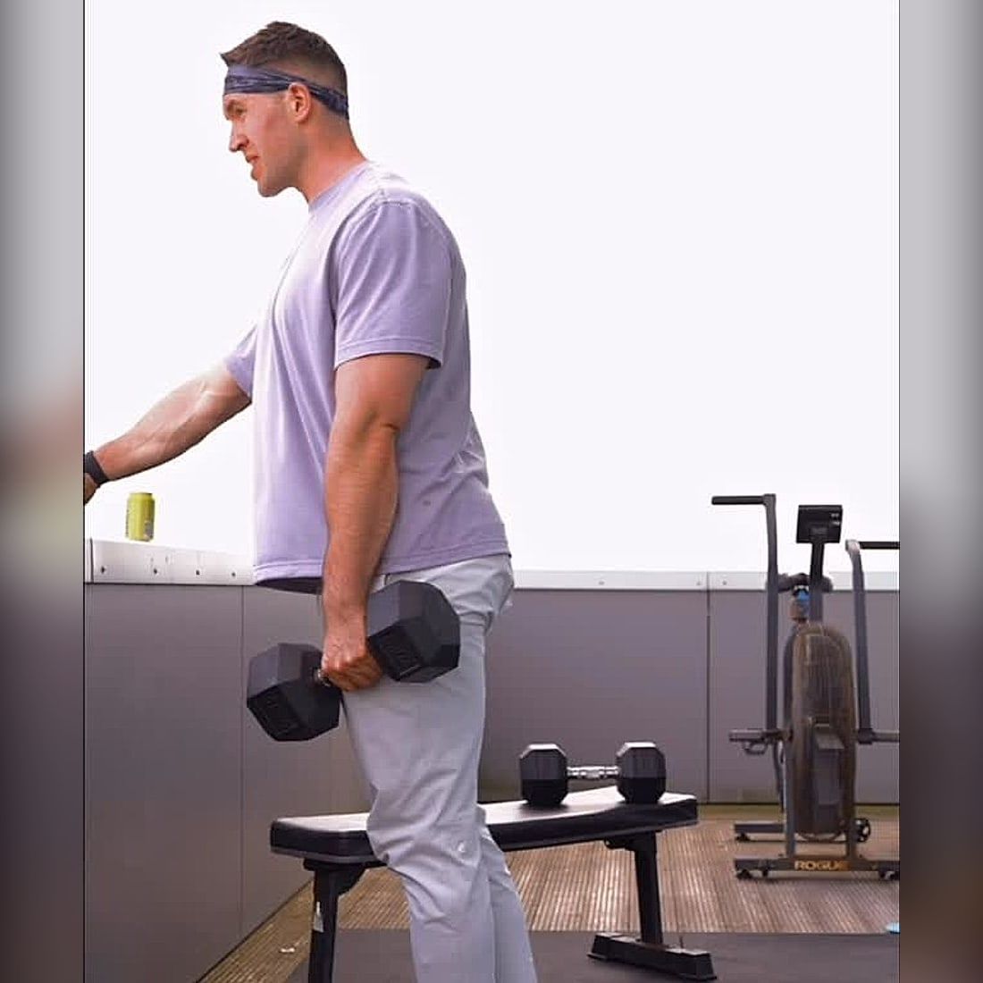 Jasper MacDermot carrying a loaded dumbbell during a rooftop strength session
