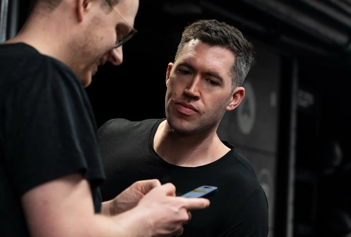 Jasper MacDermot and a client reviewing a training plan on a phone, the check-in his online clients get remotely