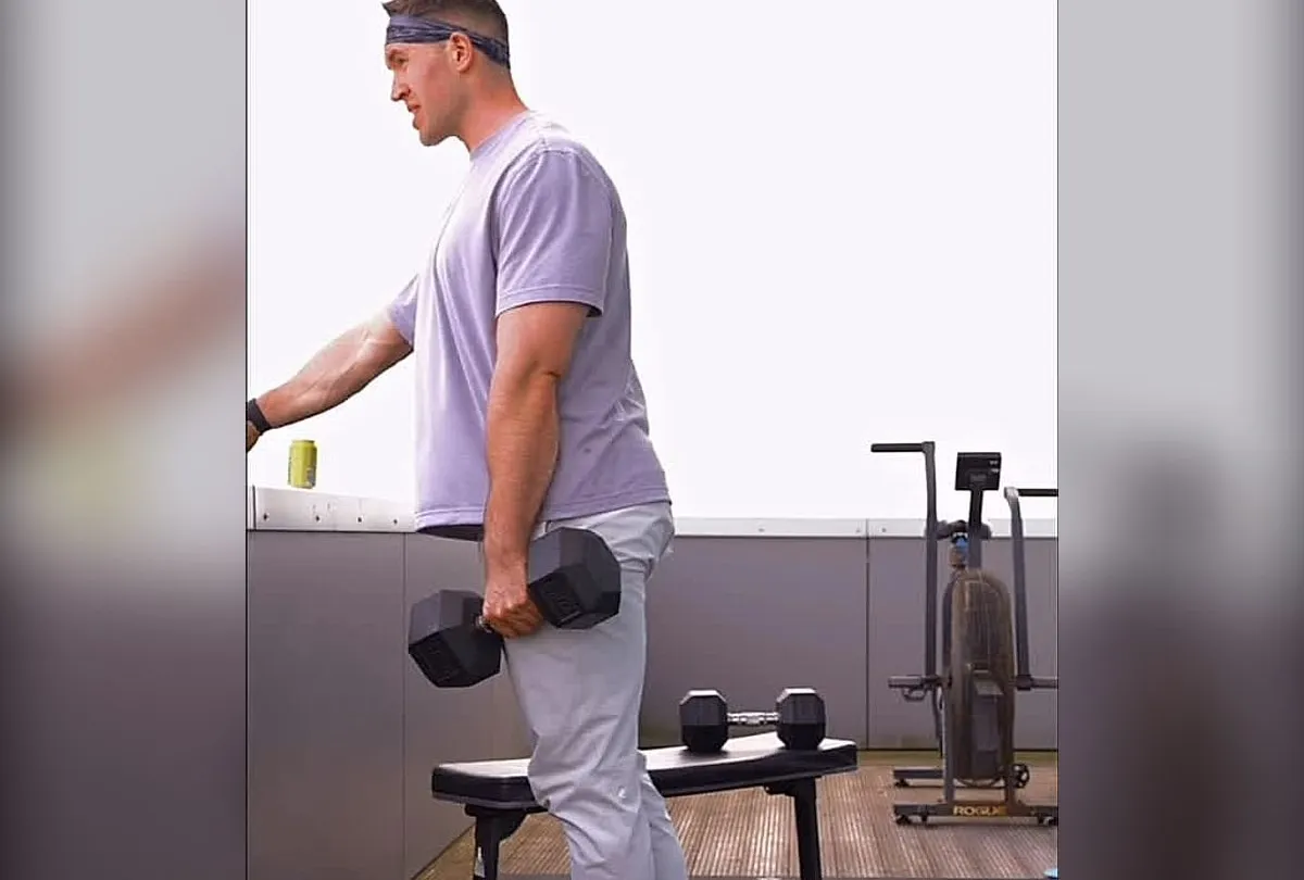 Jasper MacDermot carrying a loaded dumbbell during a rooftop strength session
