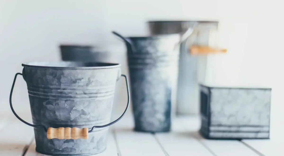 Galvanised metal buckets on a white table, the injury bucket analogy