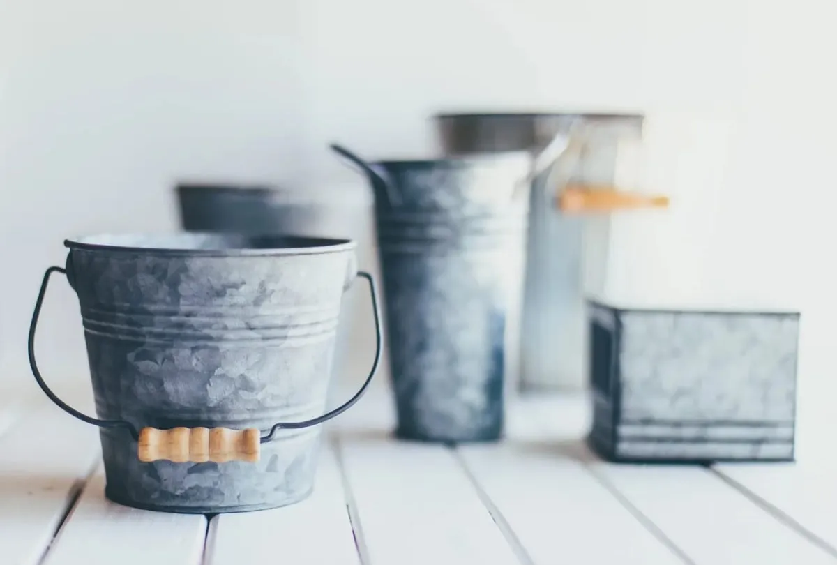 Galvanised metal buckets on a white table, the injury bucket analogy