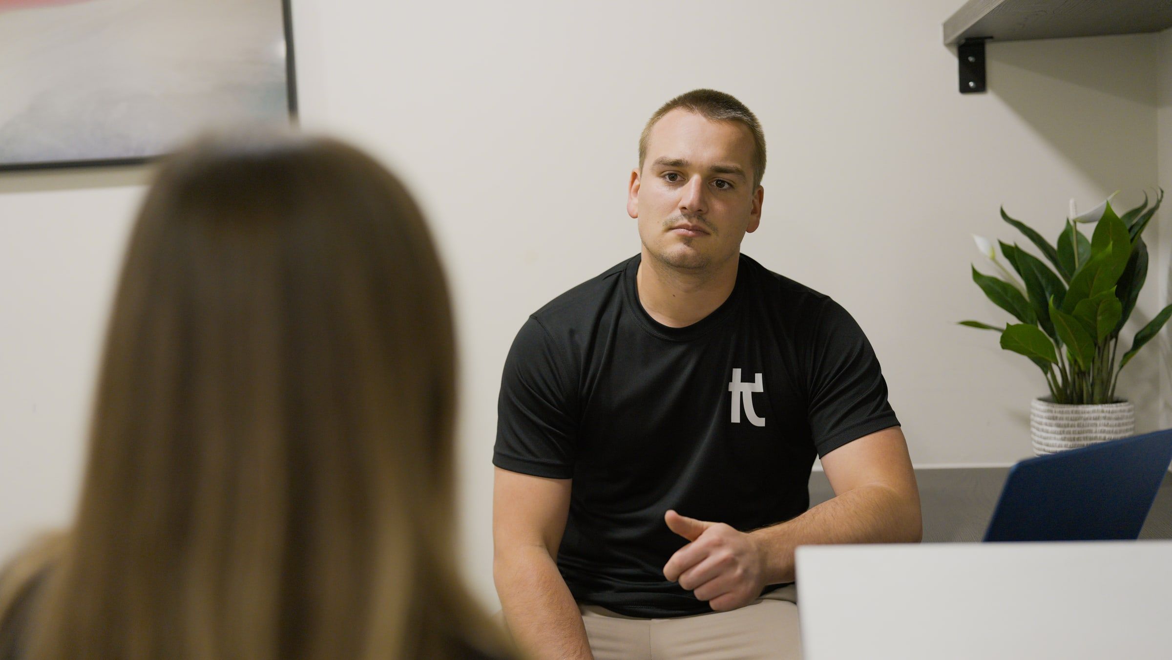 Physiotherapist Charlie listening to a patient during an initial assessment at Kaizen Physiotherapy & Performance