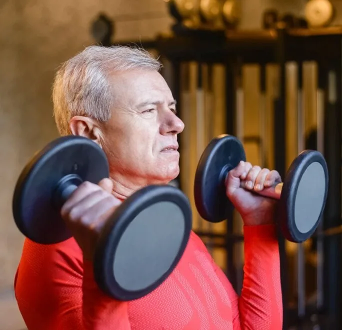 Man training with dumbbells — building muscle after 40