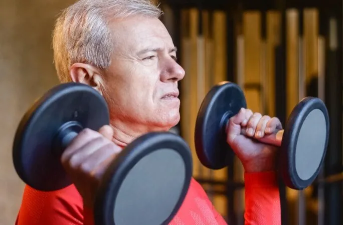 Man training with dumbbells — building muscle after 40