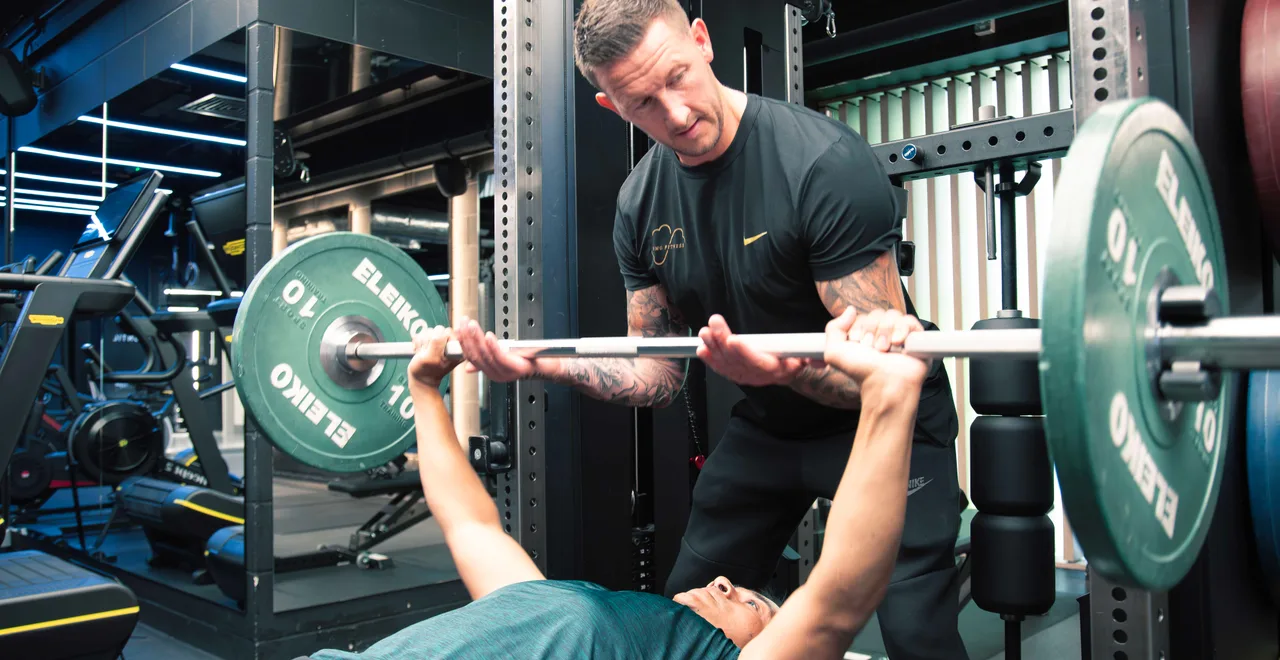 Neil McGuigan spotting a client through a controlled bench press