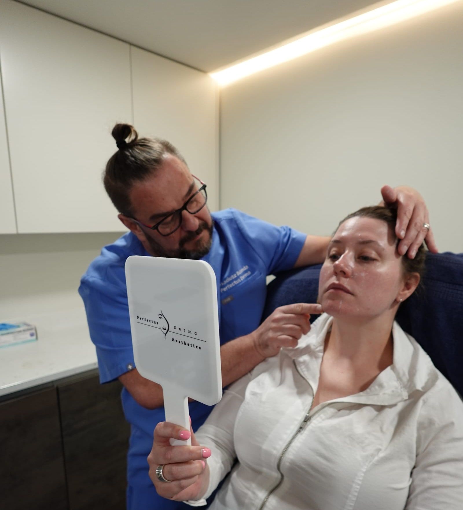 Aesthetic Nurse Practitioner reviewing a dermal filler result with a patient at Perfectus Derma Aesthetics, UNTIL Soho