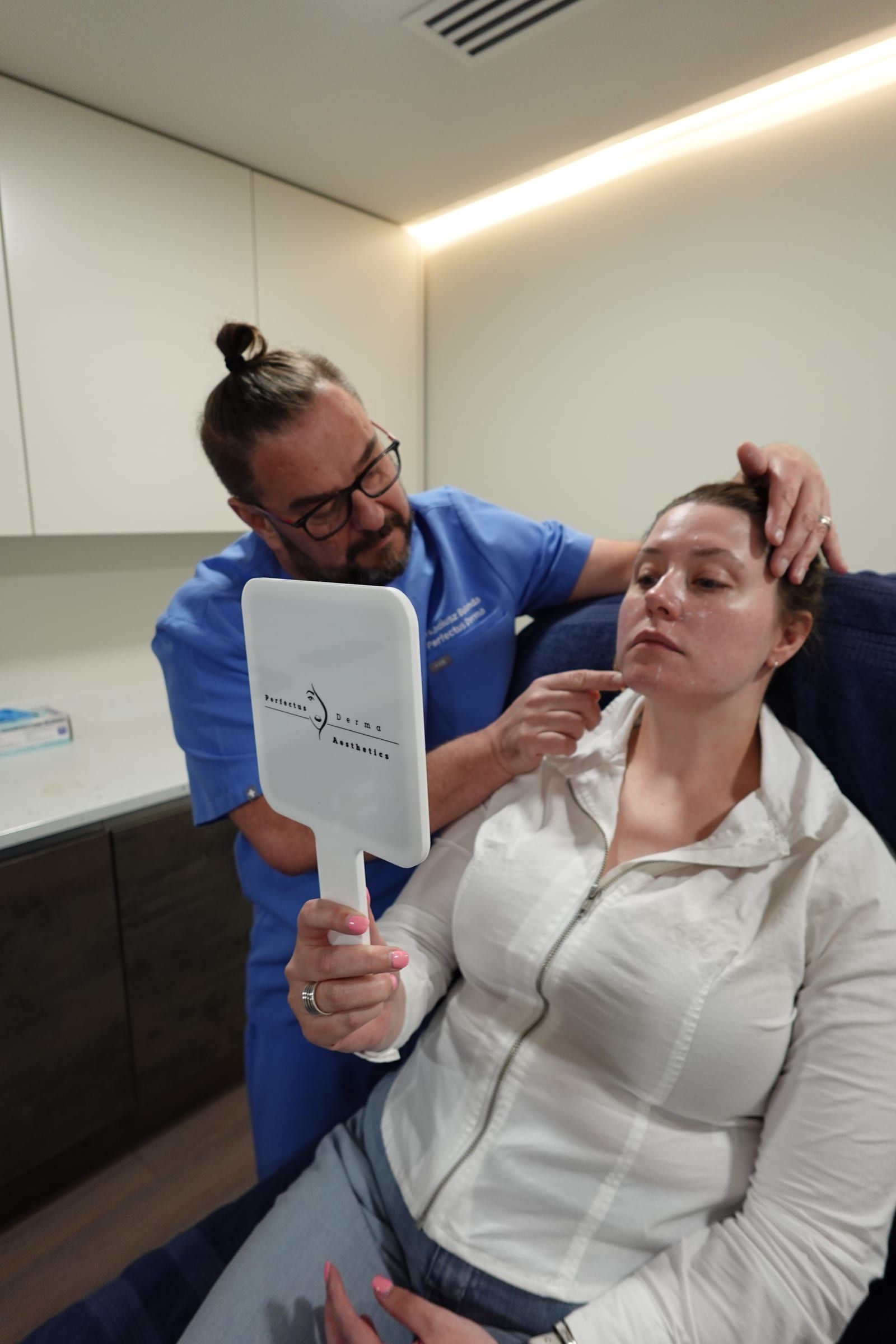 Aesthetic Nurse Practitioner reviewing a dermal filler result with a patient at Perfectus Derma Aesthetics, UNTIL Soho