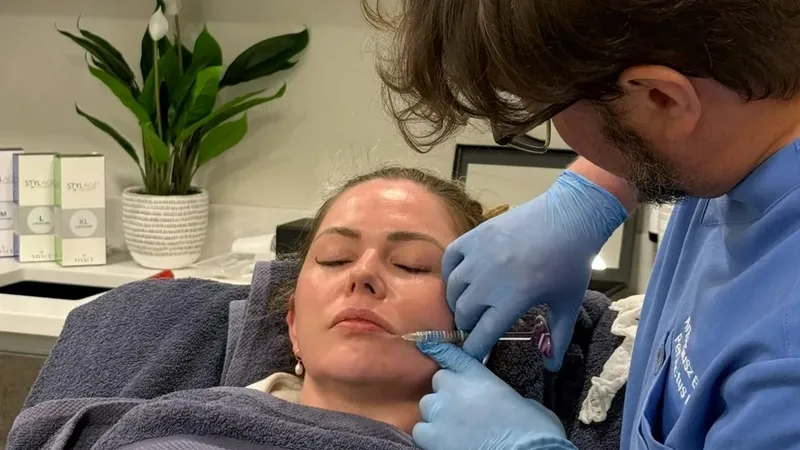 Aesthetic Nurse Practitioner placing dermal filler in a patient's mid face at Perfectus Derma Aesthetics, UNTIL Soho