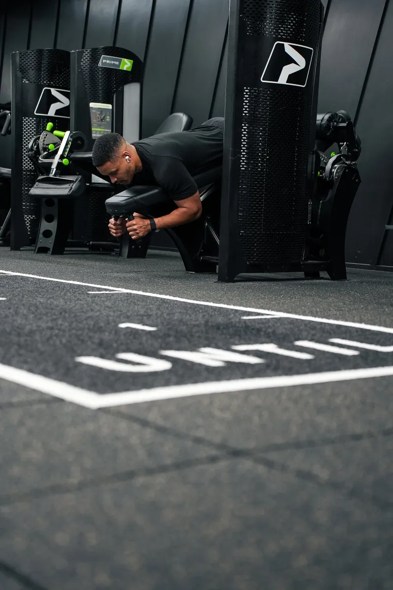 Steven Bartlett working a resistance machine, seen across the marked training lane