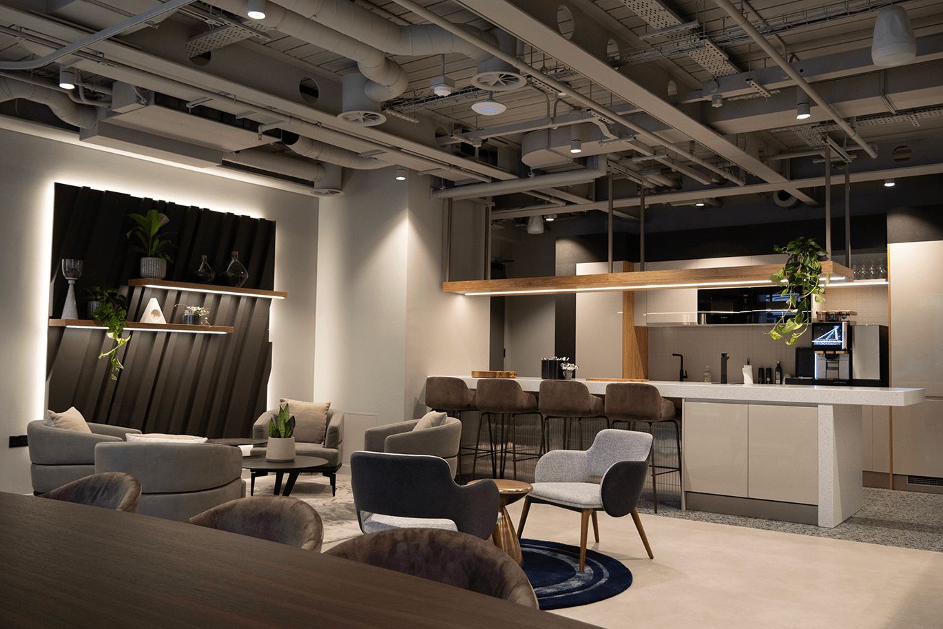 The clubhouse lounge at UNTIL Marylebone, with armchairs and a bar.