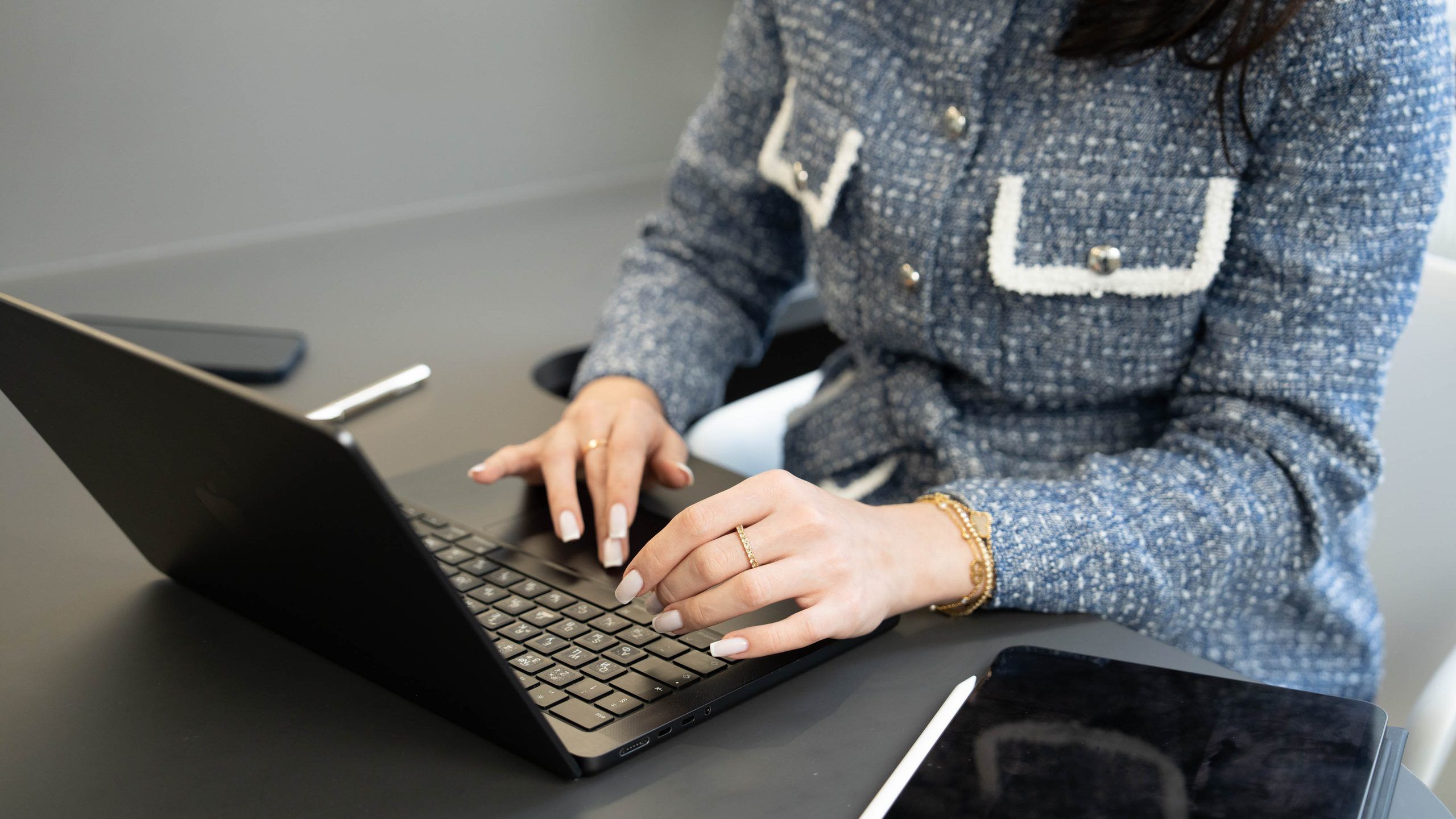 A practitioner’s hands typing consultation notes on a laptop