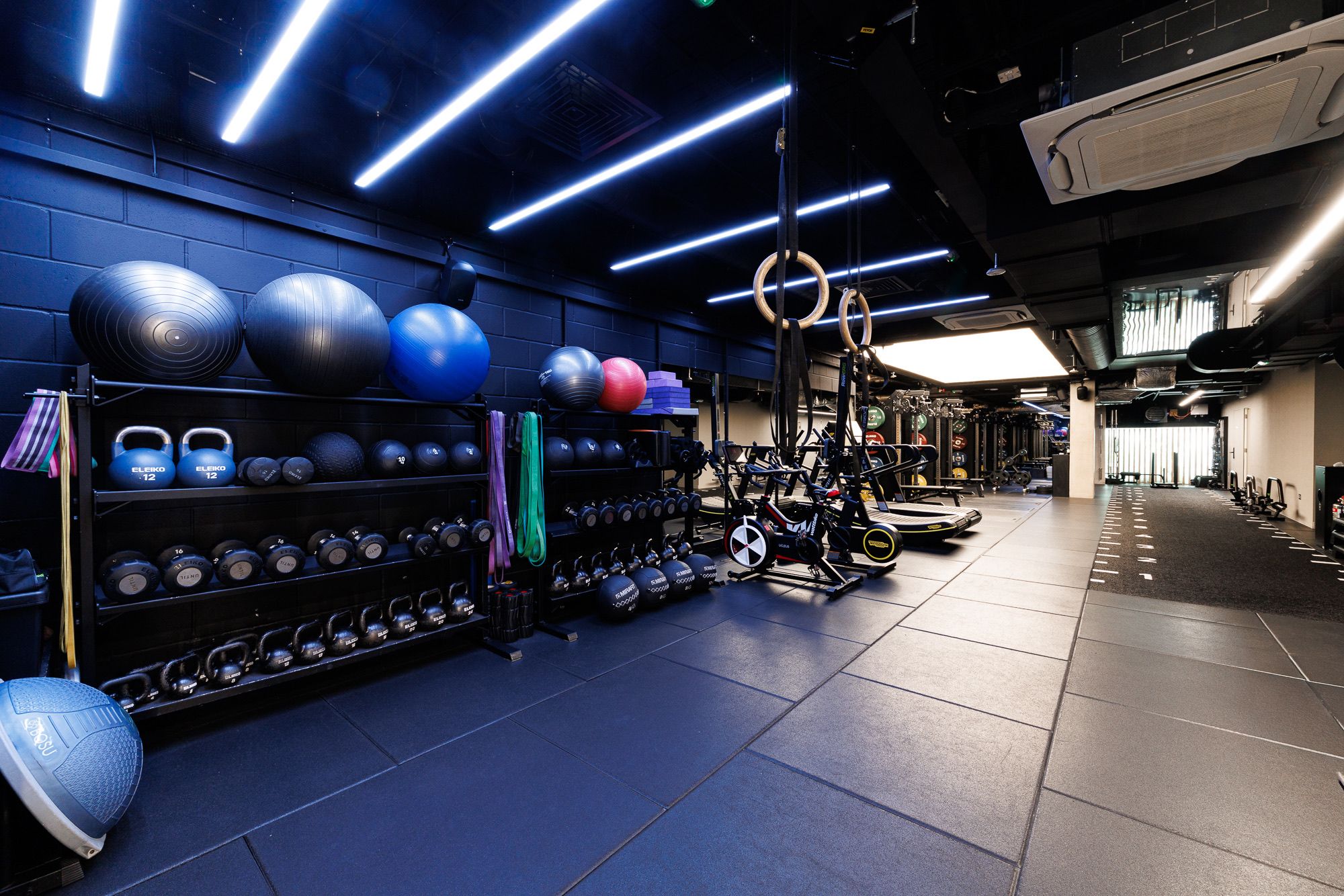 The functional and conditioning area at UNTIL Soho, with kettlebells, stability balls, and gymnastic rings