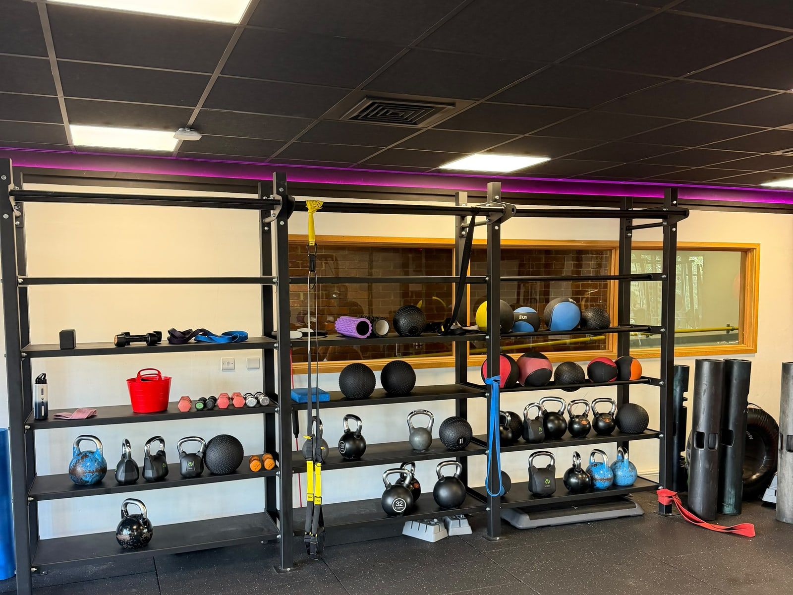 Kettlebells, medicine balls and suspension trainers racked along the gym wall at Crouch End.