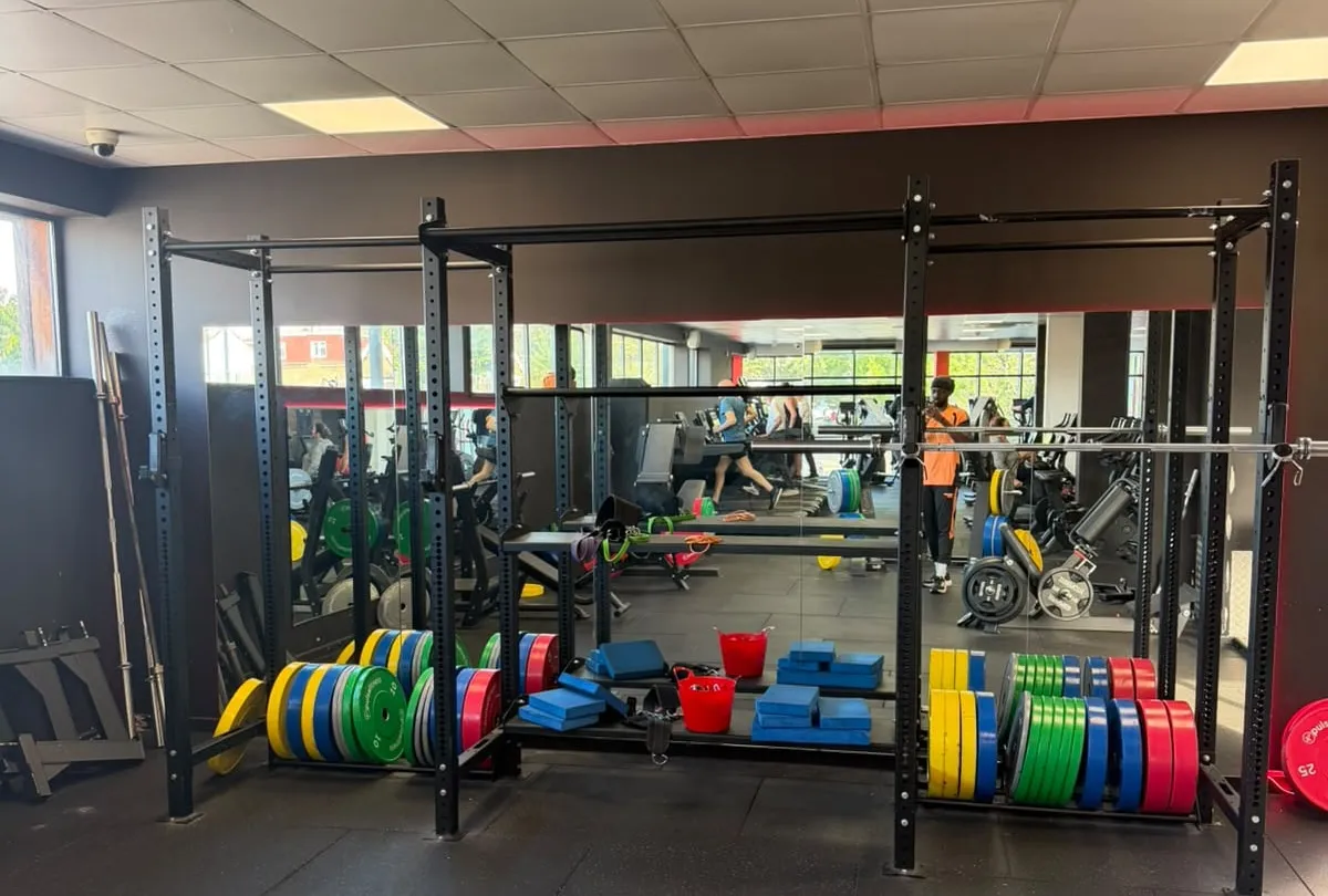 The new gym at the Crouch End clinic: a squat rack with bumper plates, and the cardio floor beyond.