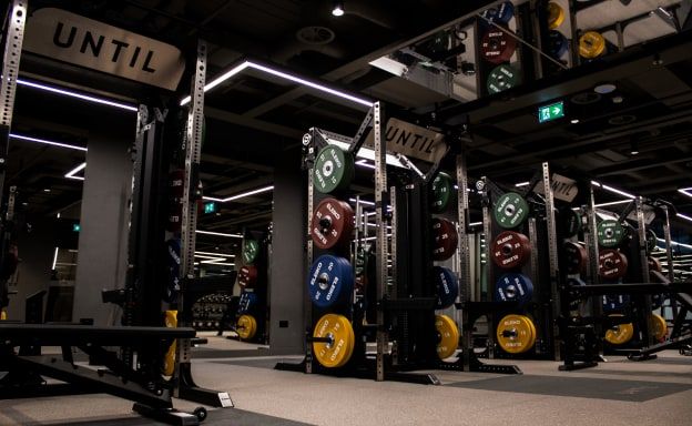 The strength training floor at UNTIL Marylebone, with racks and loaded barbells