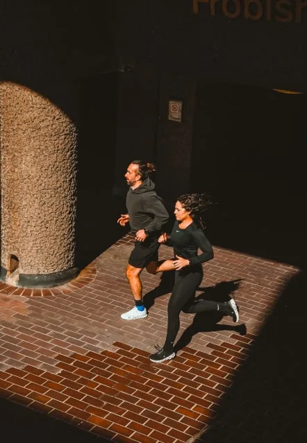Leigh Clayton of W1 Performance running with a client on a London street in the evening