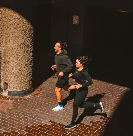 Leigh Clayton of W1 Performance running with a client on a London street in the evening